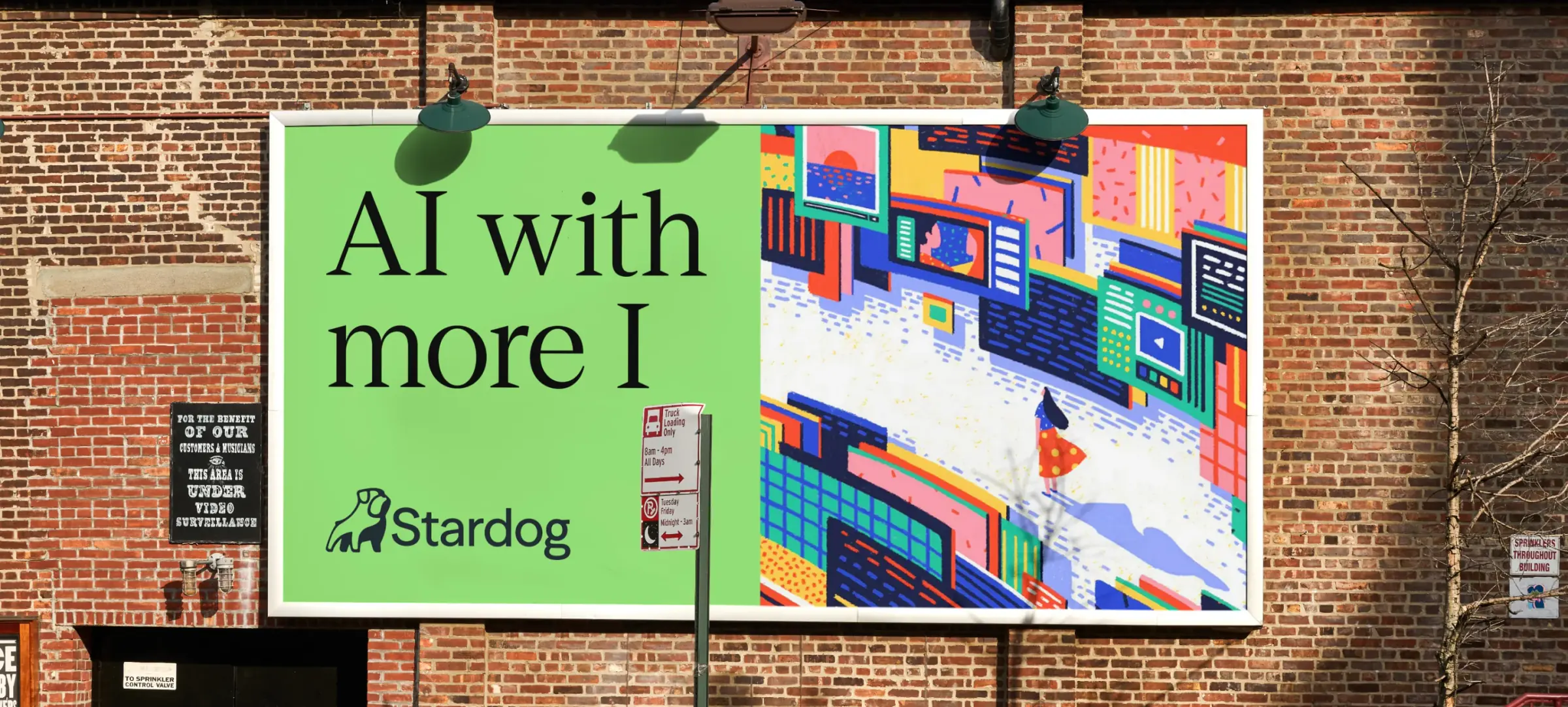 A Stardog billboard mounted on a brick wall, pairing an “AI with more I” headline with a dense, brightly coloured cityscape illustration