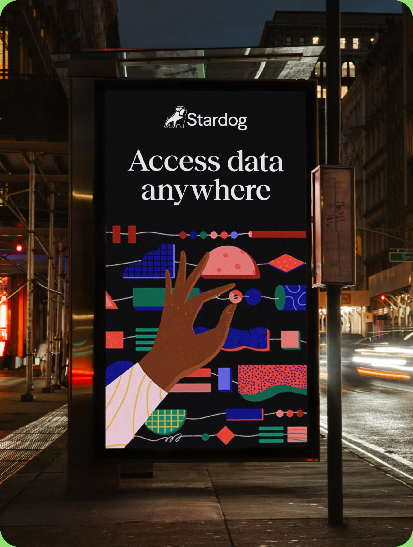 A Stardog “Access data anywhere” poster in a city bus shelter at night, its lower half filled with an illustrated hand reaching across interconnected shapes