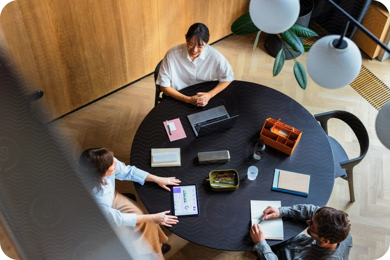 Overhead view of three colleagues working around a round table