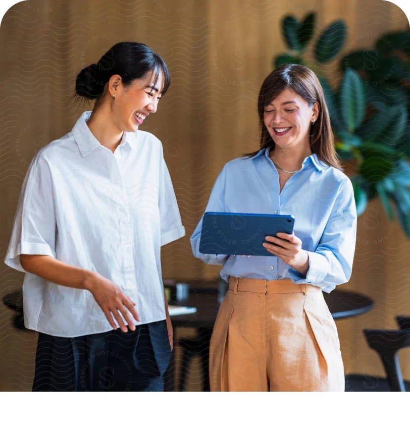 Two colleagues walking together and looking at a tablet