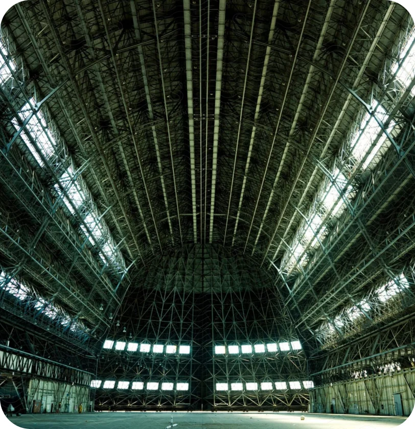 The vaulted interior of a vast aircraft hangar